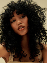 AG Care Curl Fresh Shampoo foam on hair suggests soft, manageable curls.