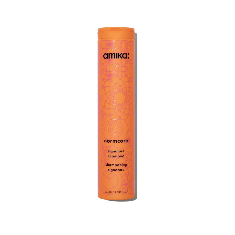 Amika Normcore Signature Shampoo bottle pour showing gentle daily cleanse and hydration