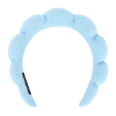 Araluky blue fluffy headband with flower-like design keeps hair dry during cleansing.