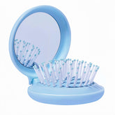 Arthaxi travel hairbrush and mirror blue folded compact in a purse for on-the-go styling.