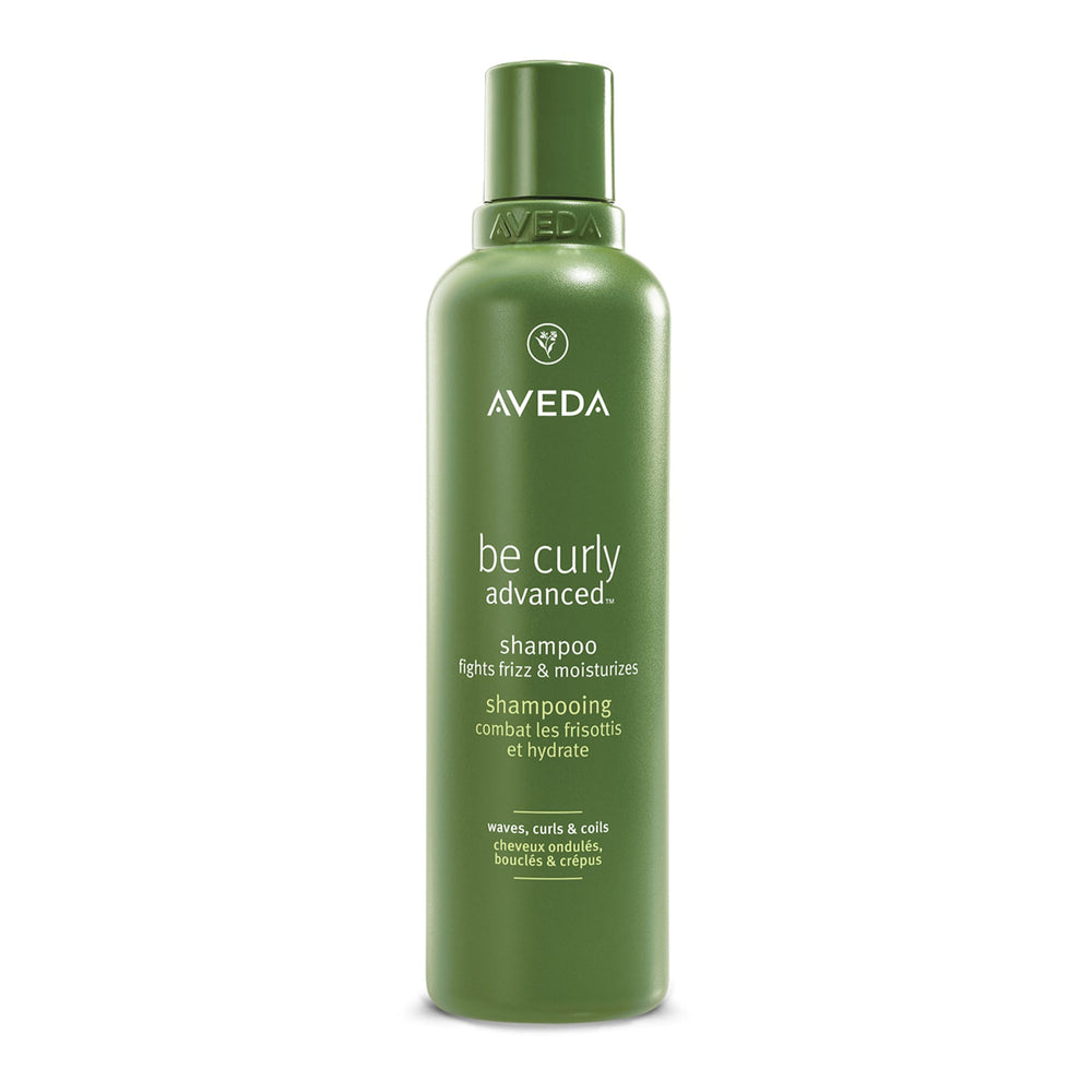 Aveda Be Curly Advanced Shampoo bottle close-up with citrus aroma for frizz control.