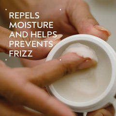 Aveda pomade jar demonstrating emulsification between hands for application.