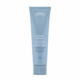 Aveda Smooth Infusion Perfectly Sleek bottle demonstrating frizz defense for textured hair.