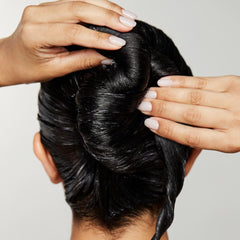 Applying Awapuhi Wild Ginger mask to damp hair.