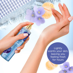 Tilted Bodycology Blue Denim Mist bottle showing travel-friendly design.