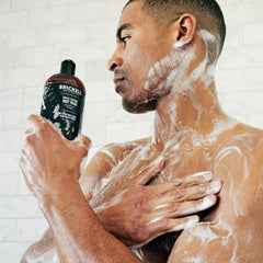 Brickell Men's Invigorating Body Wash splash with tropical teakwood scent.
