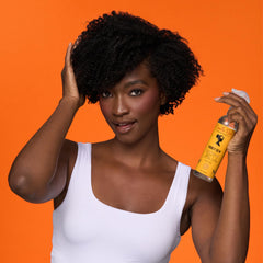 Camille Rose Curl and Detangler Spray being applied to curls for detangling.