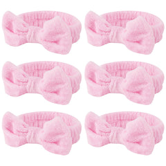 Casoty pink spa headband with bow keeps hair away during skincare.