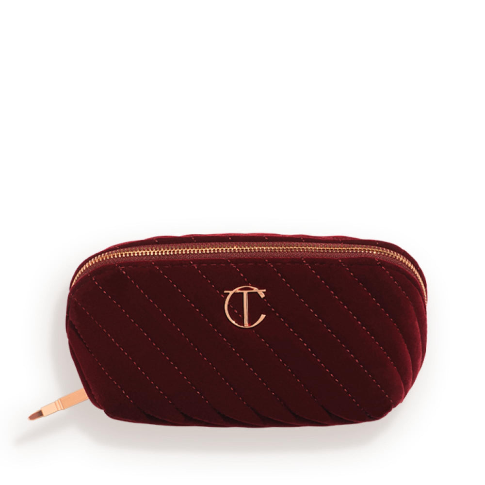 Charlotte Tilbury medium travel makeup bag in quilted velvet with three compartments for organized travel.