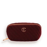 Charlotte Tilbury medium travel makeup bag in quilted velvet with three compartments for organized travel.