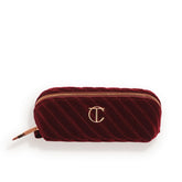 Charlotte Tilbury mini travel makeup bag in night crimson velvet for on-the-go touch-ups.