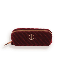 Charlotte Tilbury mini travel makeup bag in night crimson velvet for on-the-go touch-ups.