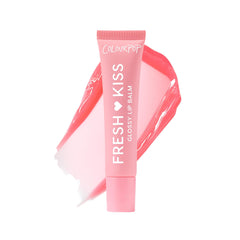 ColourPop Fresh Kiss Glossy Lip Balm in Strawberry Milk on the tube for hydrated shine.