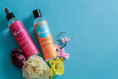 Hands applying Curls Lavish Moisturizer to damp curls for refresh.