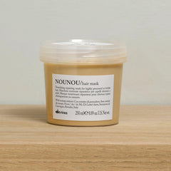 Davines Nounou Hair Mask packaging on wood surface signals premium repair for damaged hair.
