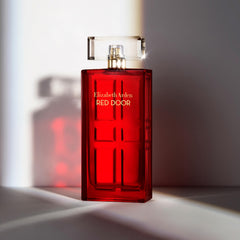 Elizabeth Arden Red Door bottle on a vanity with soft lighting.