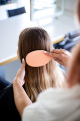 Framar Detangling Brush with elegant champagne design on vanity.