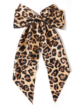 Furling Pompoms leopard satin bow camel close-up highlighting premium material and bold pattern.