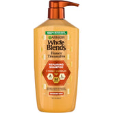Garnier Whole Blends Honey Treasures champú con envase plástico reciclado para cuidado sostenible.