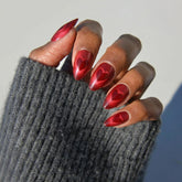 Glamnetic Enviado Con Amor: uñas almendra rojas con corazones ojo-gato magnéticos.