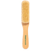 GranNaturals boar bristle brush close-up on soft white bristles for smooth styling.