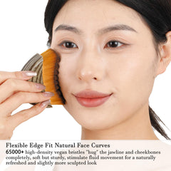 Hoyecl No Oil brush pressed on cheek demonstrates gentle massage.
