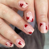 Hrnsnails Uñas Valentine: diseño corto y cuadrado con puntos blancos y corazón rojo.