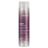 Joico Defy Damage Shampoo bottle being poured for color-safe cleansing