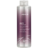 Joico Defy Damage Shampoo bottle close-up showing rich lather for color protection.
