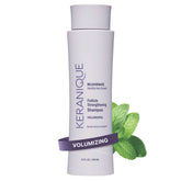 Keranique Volumizing Shampoo bottle on a vanity promoting fuller hair