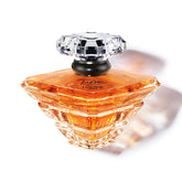 Lancôme Trésor bottle with crystal pyramid cap, elegant centerpiece for romance.