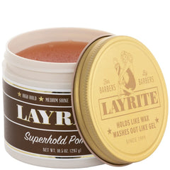 Hands applying Layrite Super Hold Pomade for even distribution on thick hair.