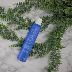 Hair styling scene with Loma Exotic Melon spray providing humidity resistance.