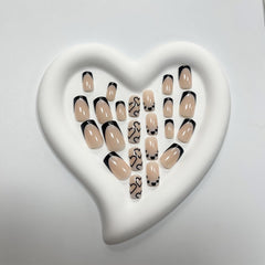 Maigitur uñas negras, diseño corazón blanco en forma corta y cuadrada.