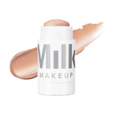 Milk Makeup Lit highlighter stick on cheekbones for radiant glow.