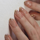 Uñas Mivota Almond rosas con French tips dorados para un look elegante