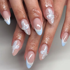 Mivota blue French tip almond nails with butterfly pearls for an elegant look.