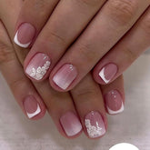 Uñas Mivota: conjunto corto blanco-nude con flores plateadas para look elegante