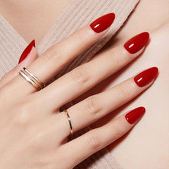 Modelones almond nails close-up showing glossy red finish.