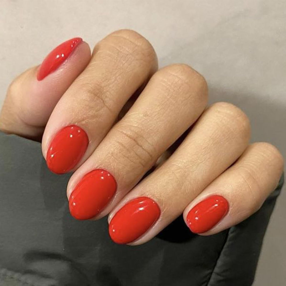 Modelones red short press-on nails oval closeup for quick, chic manicure at home.