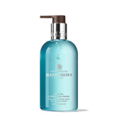Molton Brown Coastal Cypress & Sea Fennel bottle pouring for a refreshing cleanse