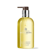 Molton Brown Orange & Bergamot hand wash bottle pour for uplifting citrus cleanse.