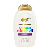 OGX Damage Remedy Coconut Miracle Oil Shampoo bottle promoting frizz control and shine.
