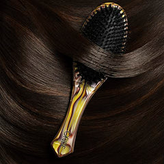 Oribe Flat Brush demonstrates ergonomic grip in use for precise styling.