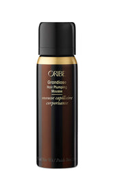 Oribe Grandiose Mousse, botella, aporta cuerpo suave y volumen duradero.