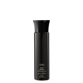 Oribe Royal Blowout spray bottle releasing a light mist for smooth, protected hair.