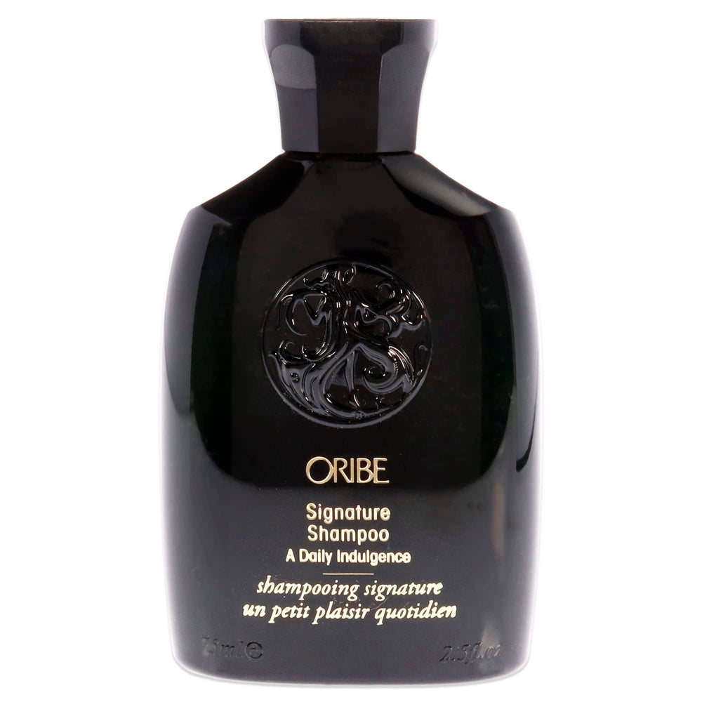 Oribe Signature Shampoo bottle pouring, providing a rich daily cleanse for all hair types.