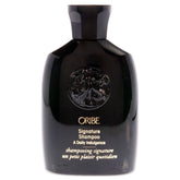 Oribe Signature Shampoo bottle pouring, providing a rich daily cleanse for all hair types.