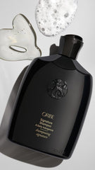 Oribe Signature Shampoo packaging on shelf emphasizes premium care.