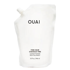 OUAI Fine Hair Conditioner refill bottle close-up showing sleek packaging for voluminous hair.